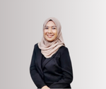 Seseorang berpenutup kepala krem mengenakan blazer hitam, berdiri dengan tangan disilang di depan tubuh; latar belakang gradasi abu-abu terang, bersih, dan bergaya minimalis.